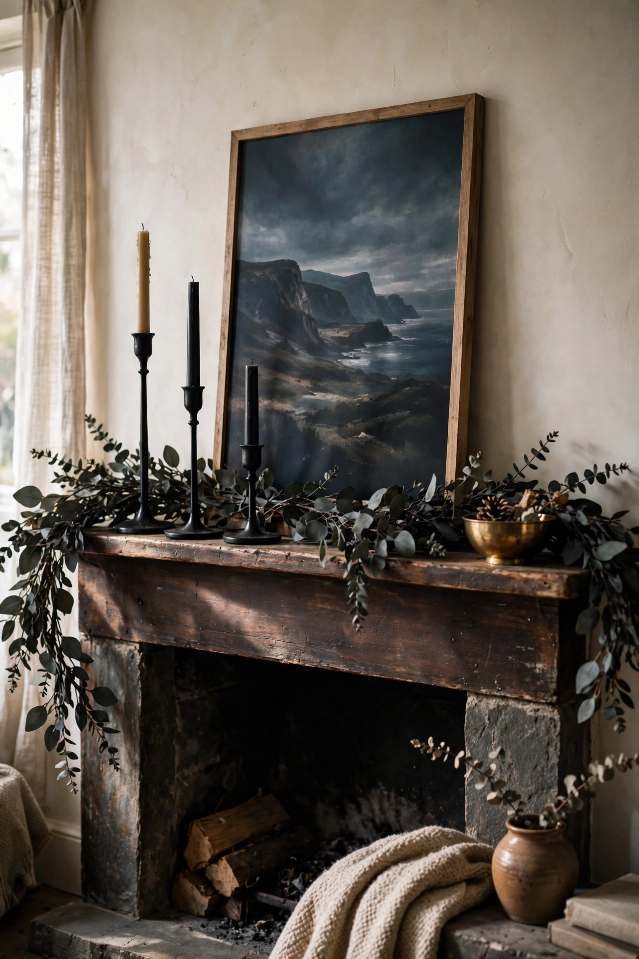 Fireplace mantel styled with dark garland and black candlesticks