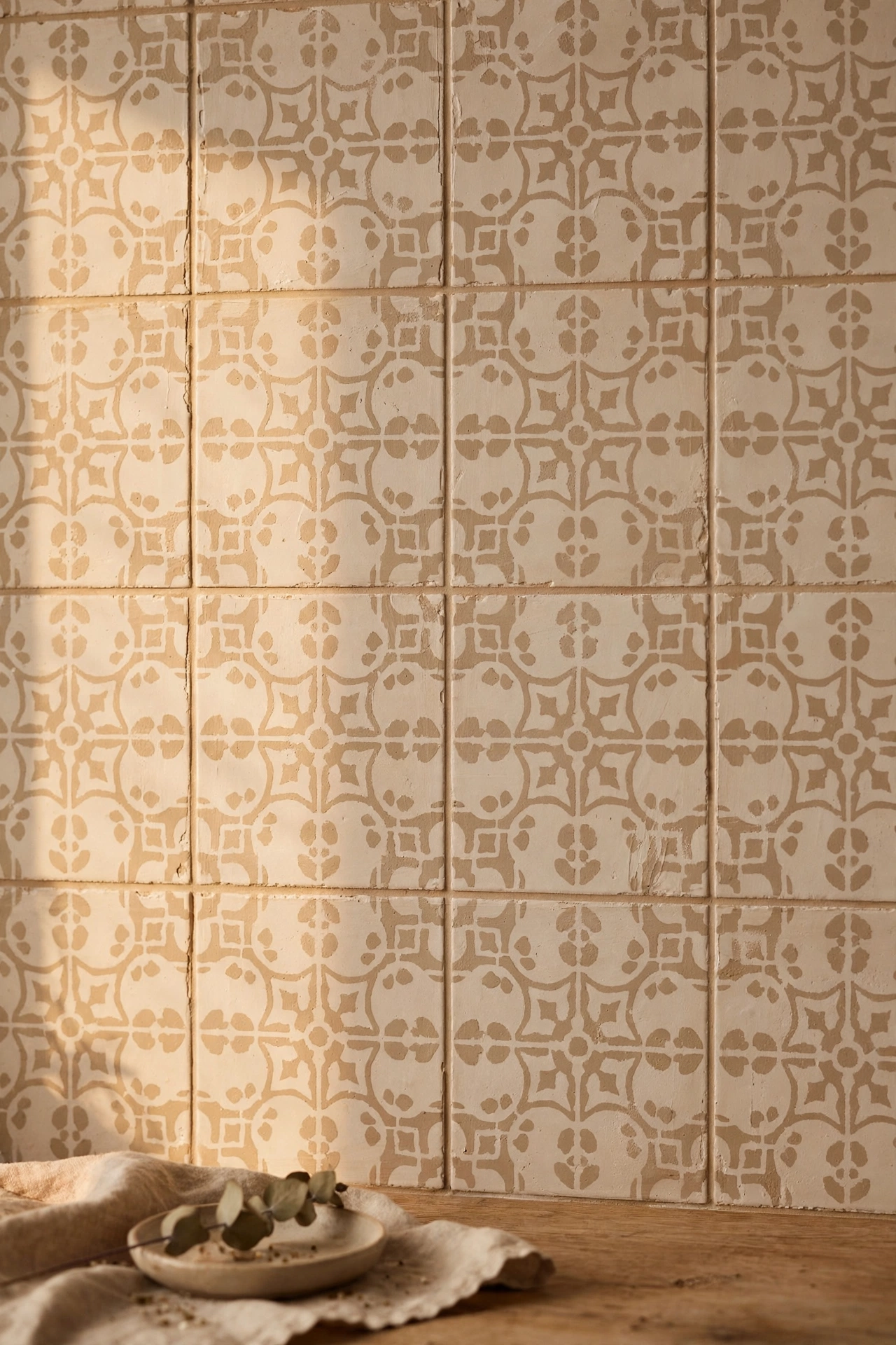 Plain tiles stencilled with a beige tone-on-tone pattern