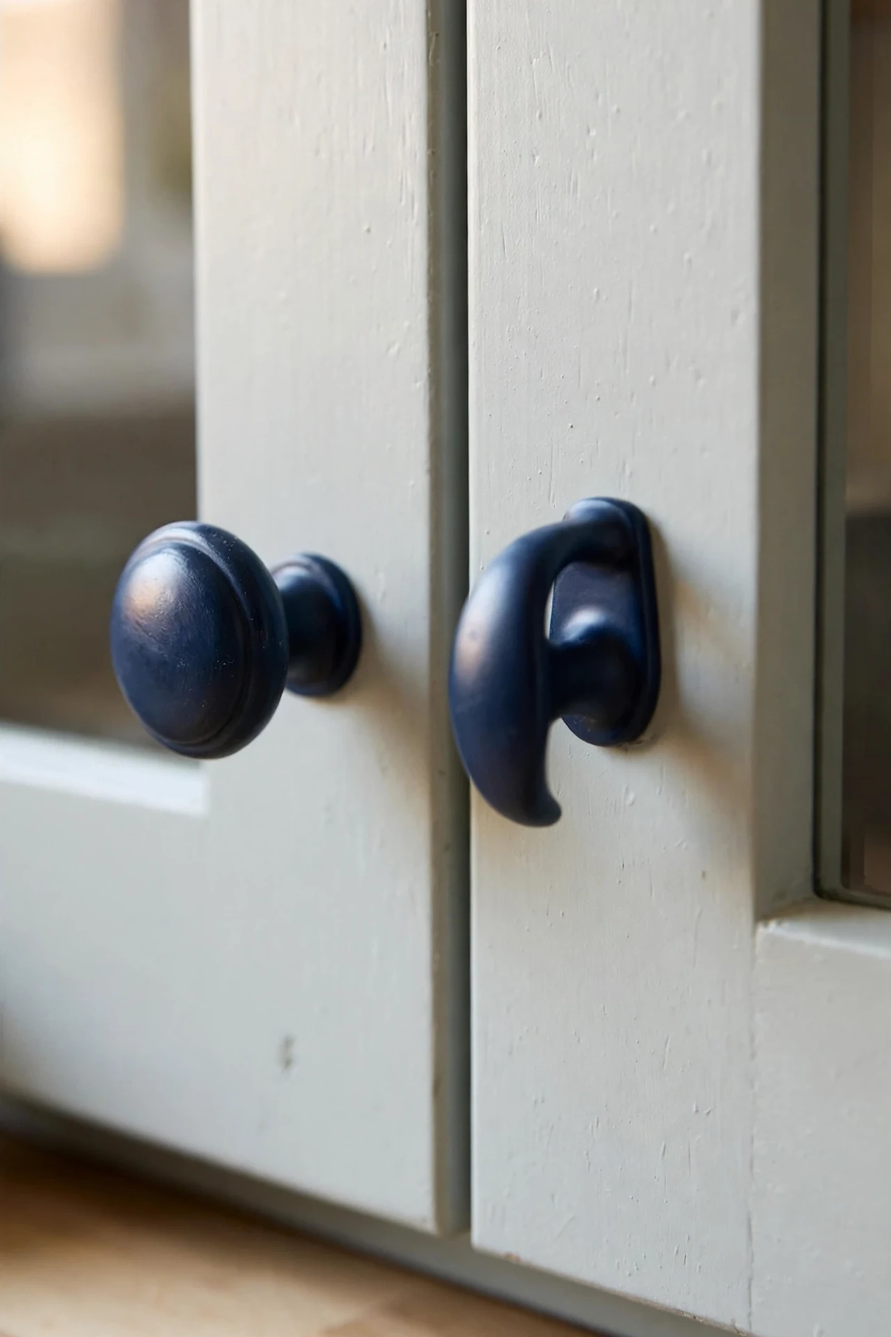 Navy cabinet knobs and handles on pale kitchen cabinets