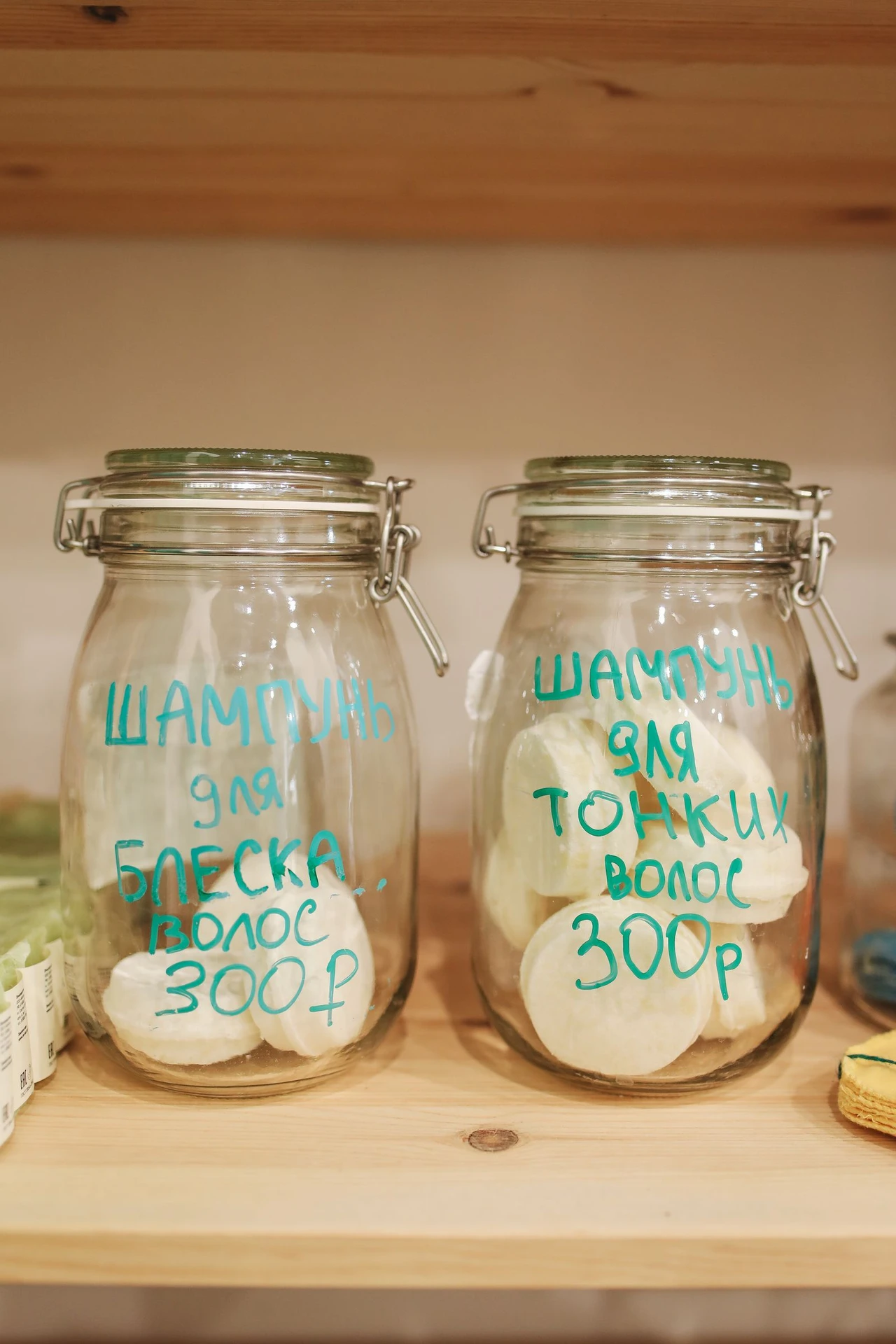 Glass jars wrapped in natural twine holding cotton balls and bath salts on a bathroom shelf