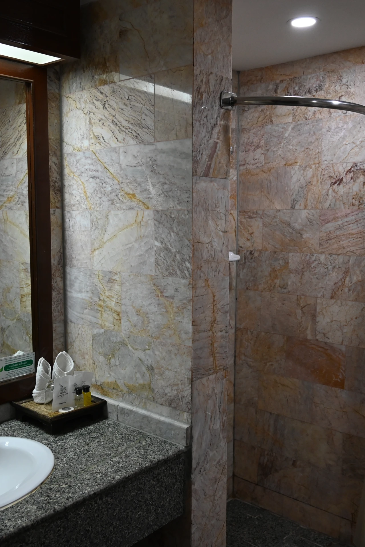 Bathroom vanity top covered in white marble look contact paper with gold fixtures