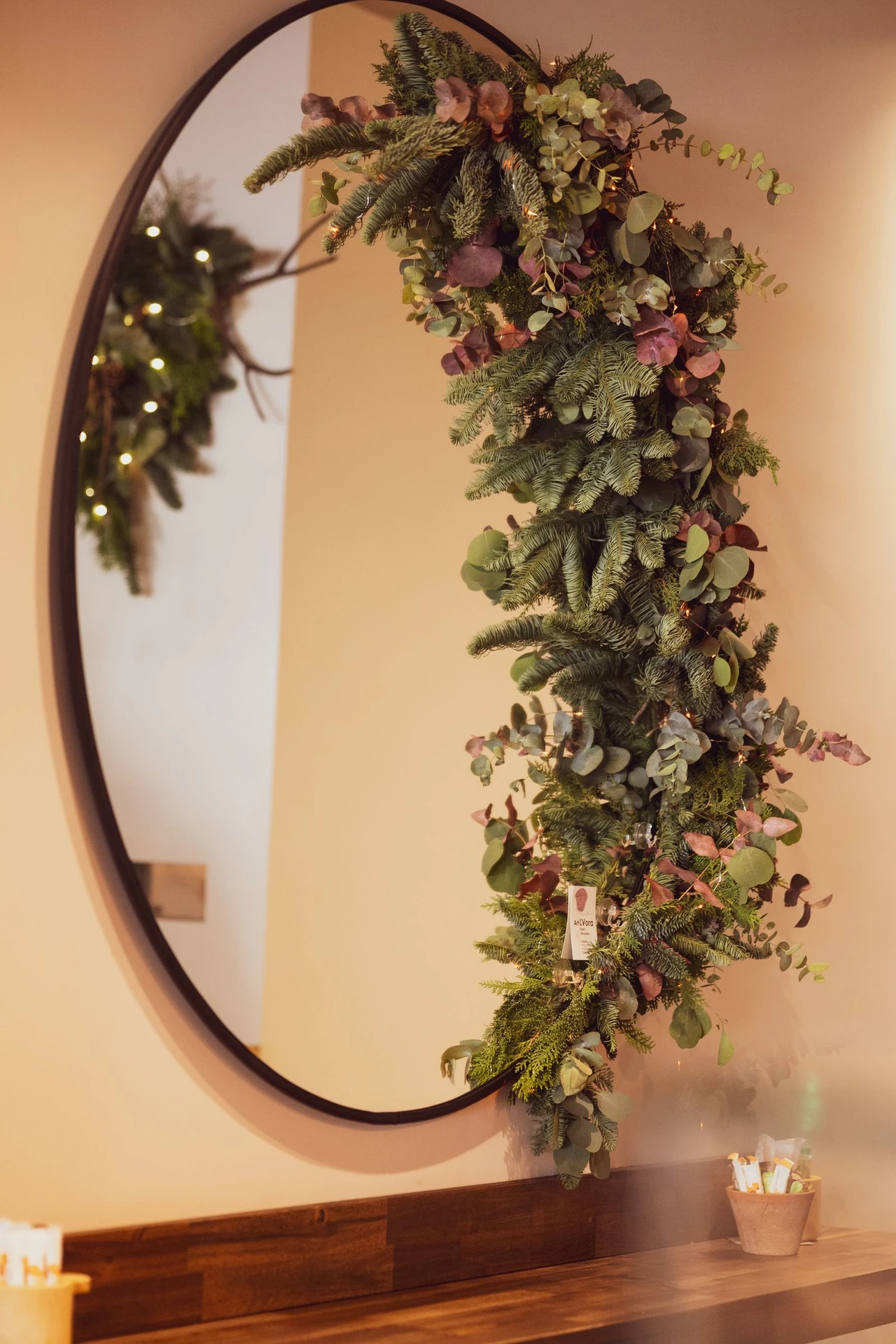 Faux eucalyptus garland draped over the top of a bathroom mirror