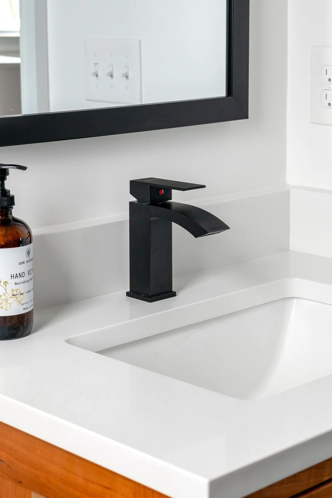 Sleek matte black faucet on a white modern bathroom sink