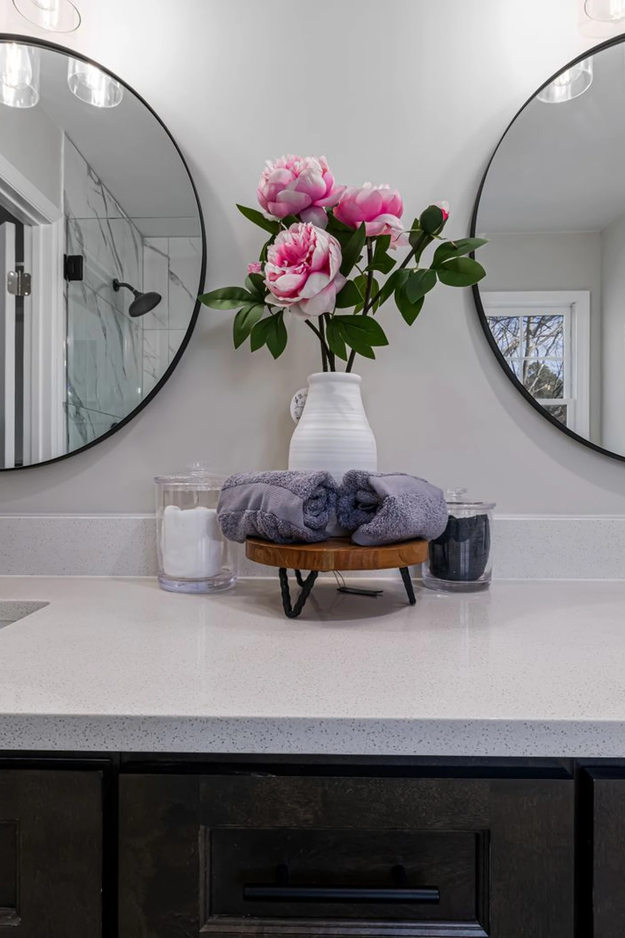 Large round mirror hanging over a modern bathroom vanity
