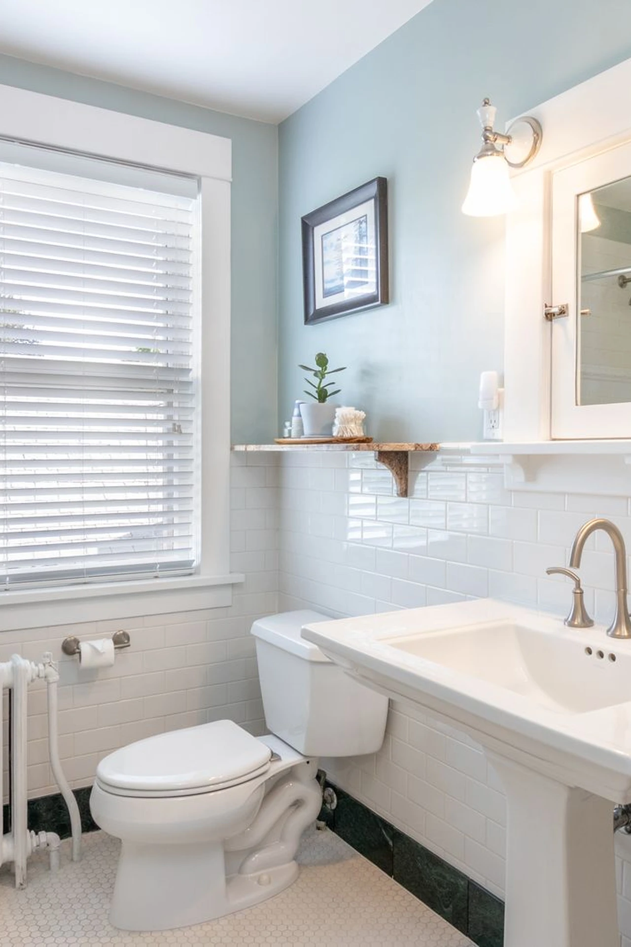 Floating wooden shelves above a toilet holding rolled towels