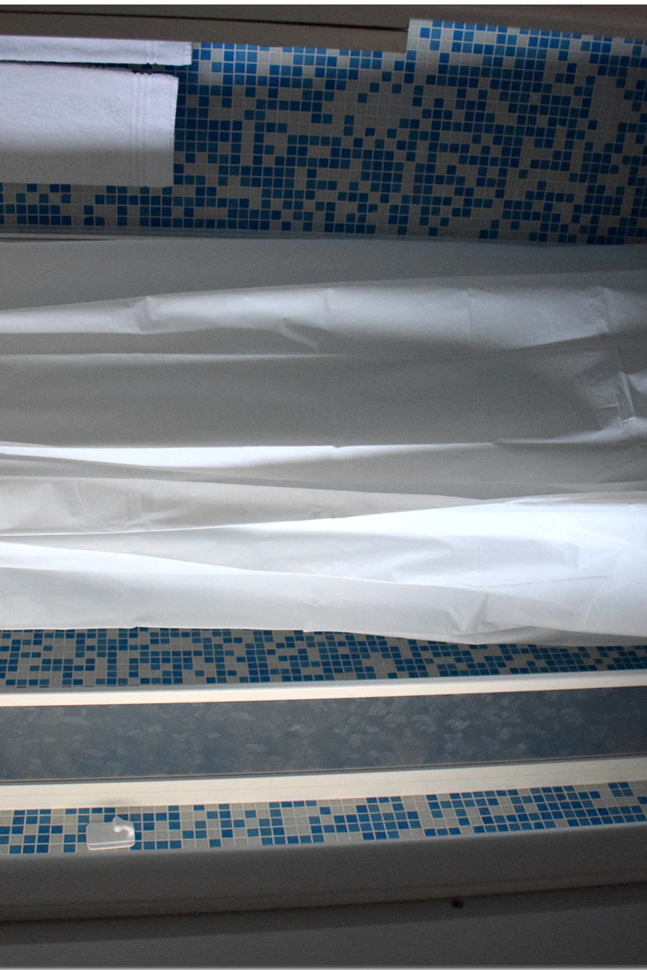 Linen-Look Curtain That Softens Hard Tile in a cozy budget bathroom with soft natural light