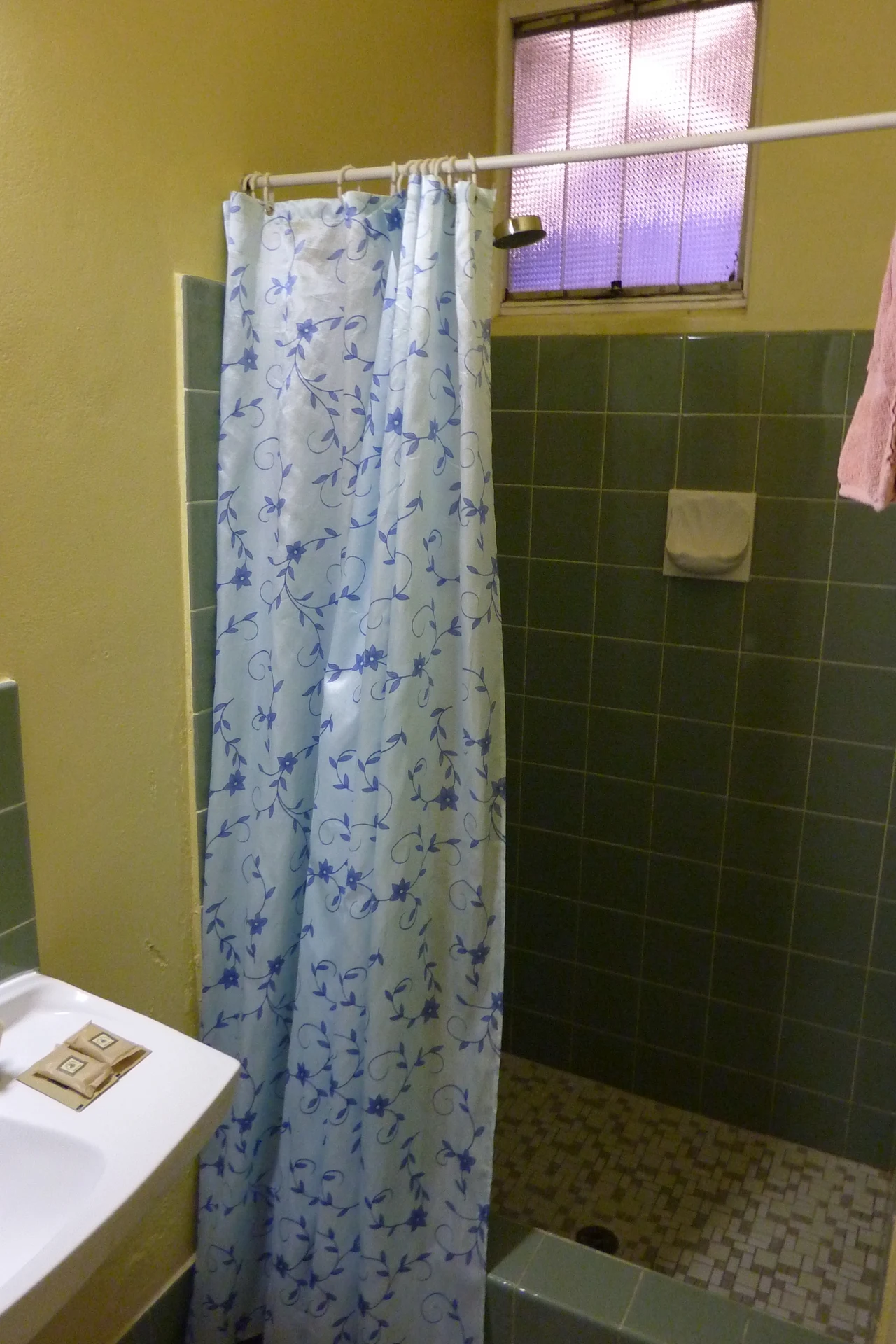 Extra-Long Curtain Hung From the Ceiling in a cozy budget bathroom with soft natural light