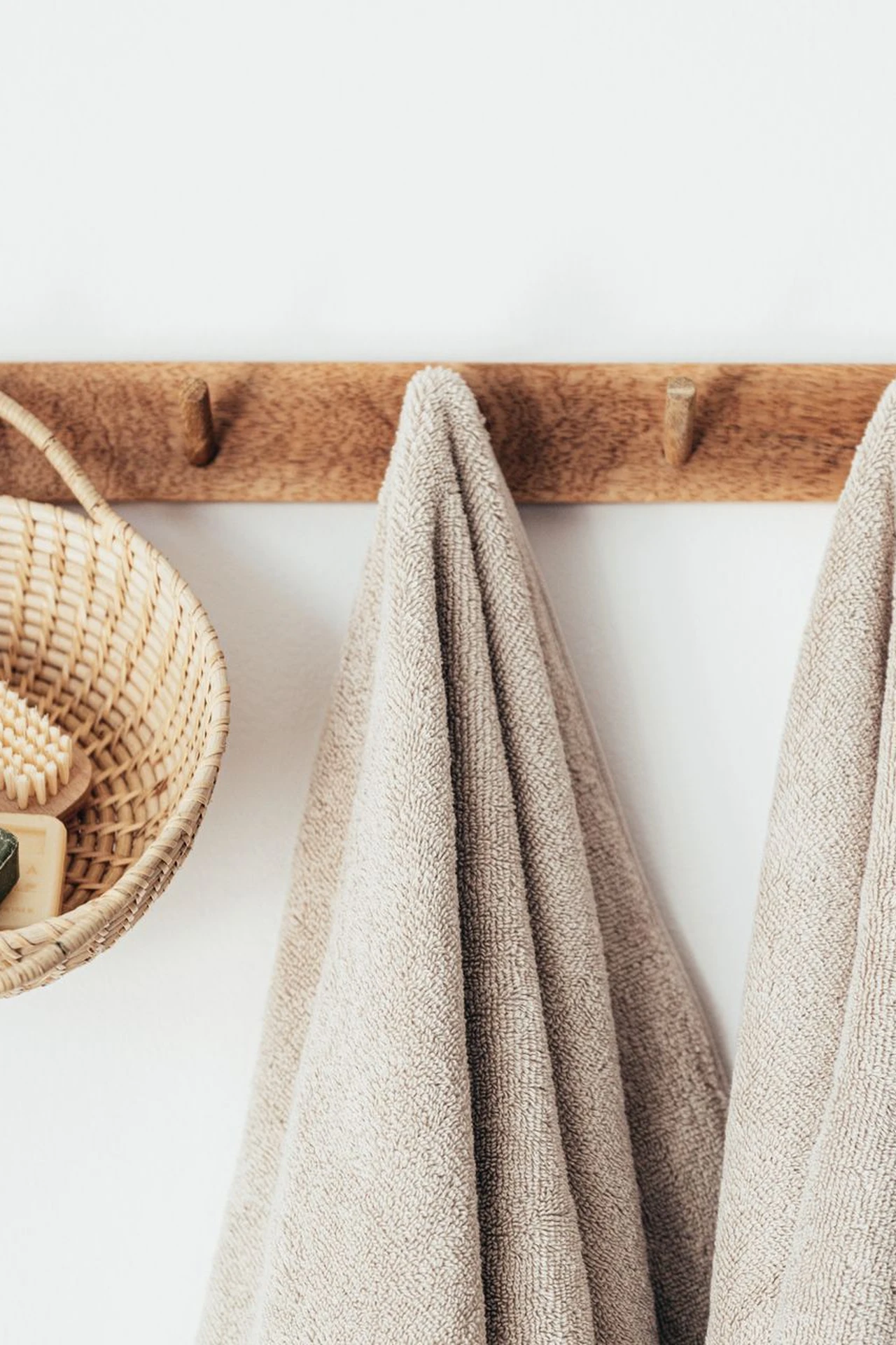 Mustard woven baskets holding rolled white towels in a bathroom