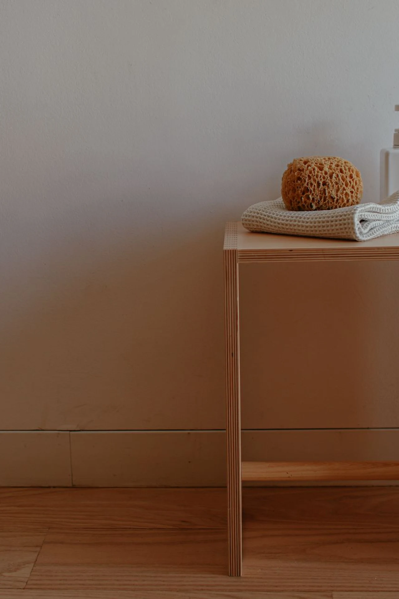 Mustard painted wooden stool beside a bathroom vanity