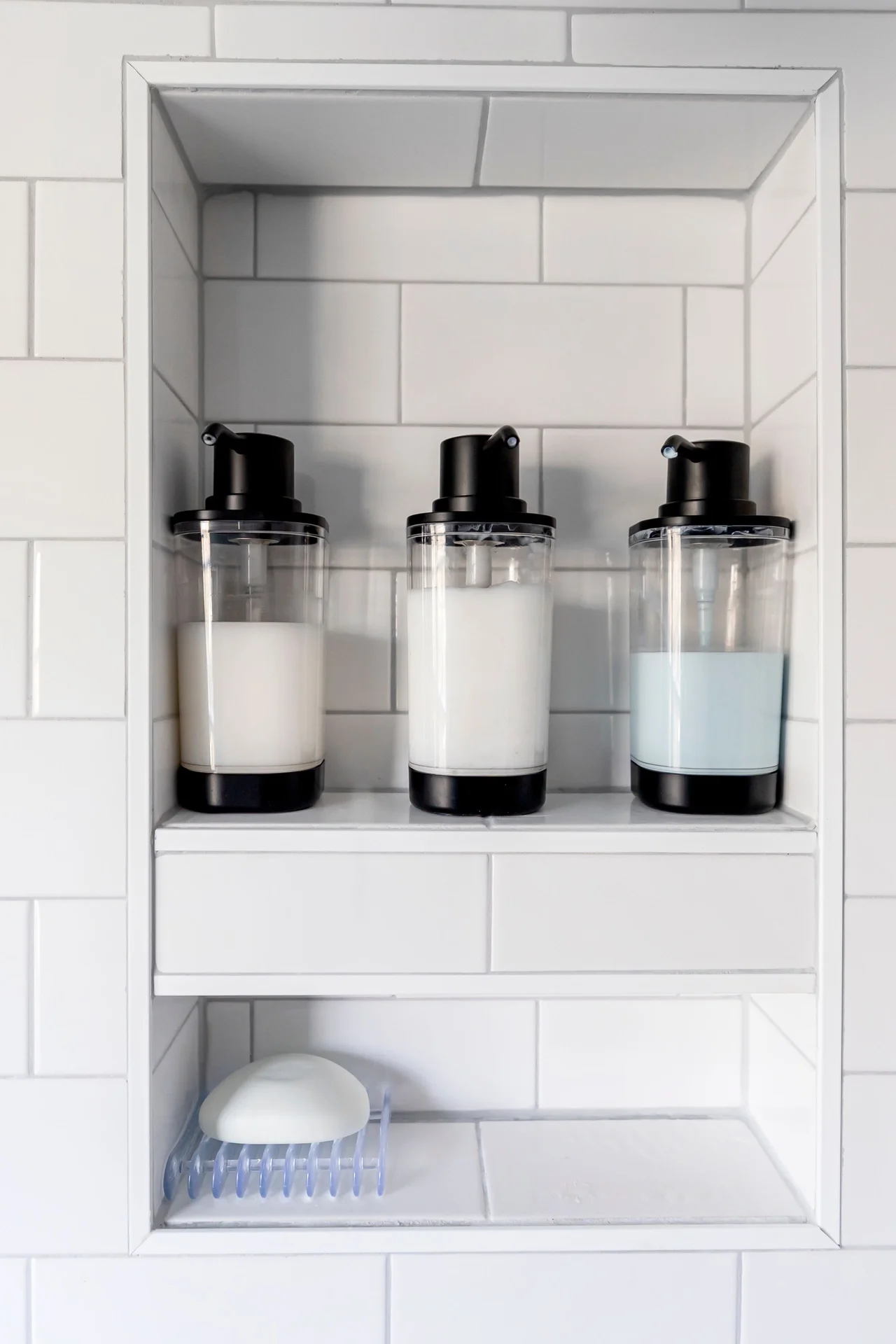 Fold-down wall shelf holding a hair dryer in a tiny bathroom