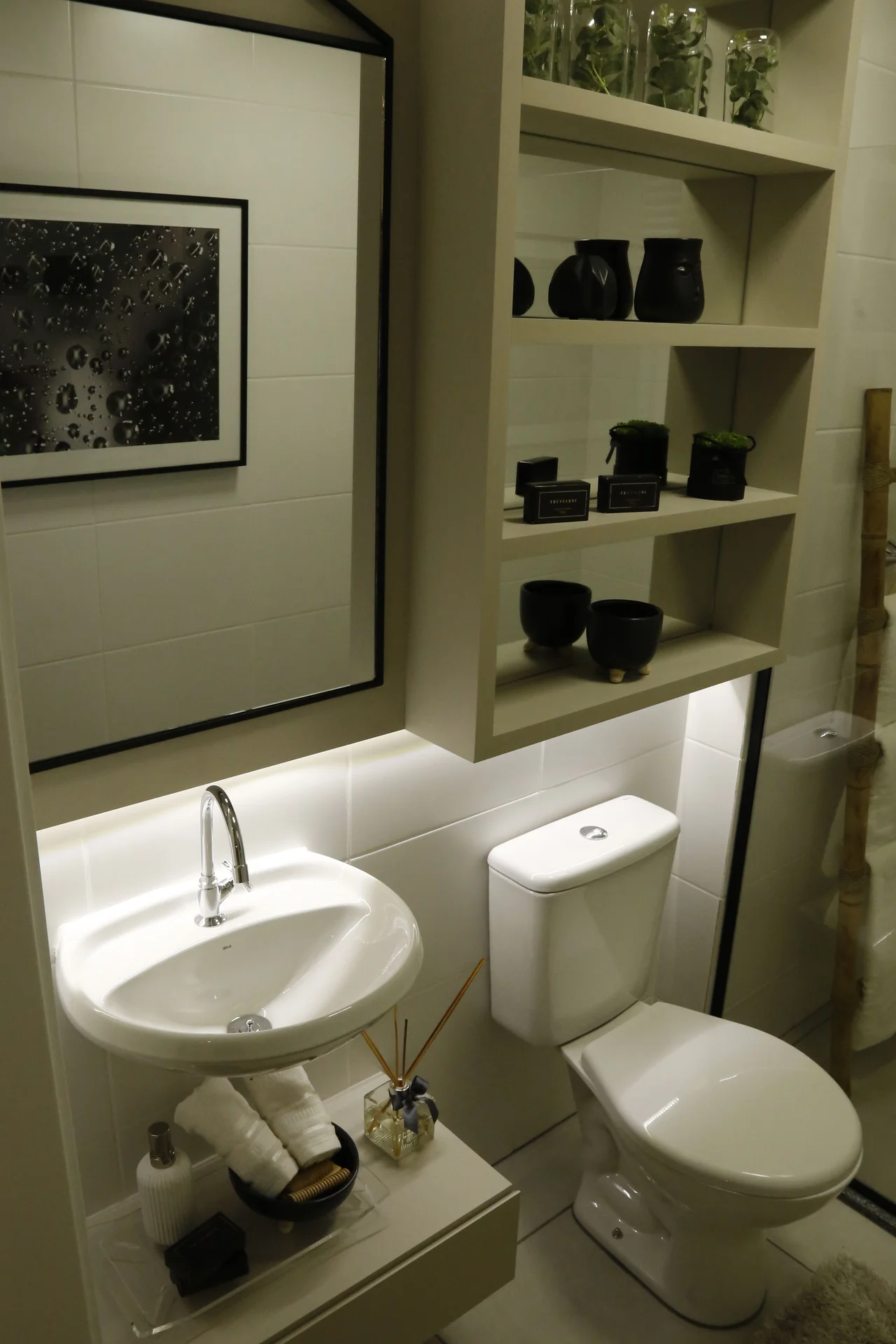 Tension rods with a shelf above a toilet tank holding towels