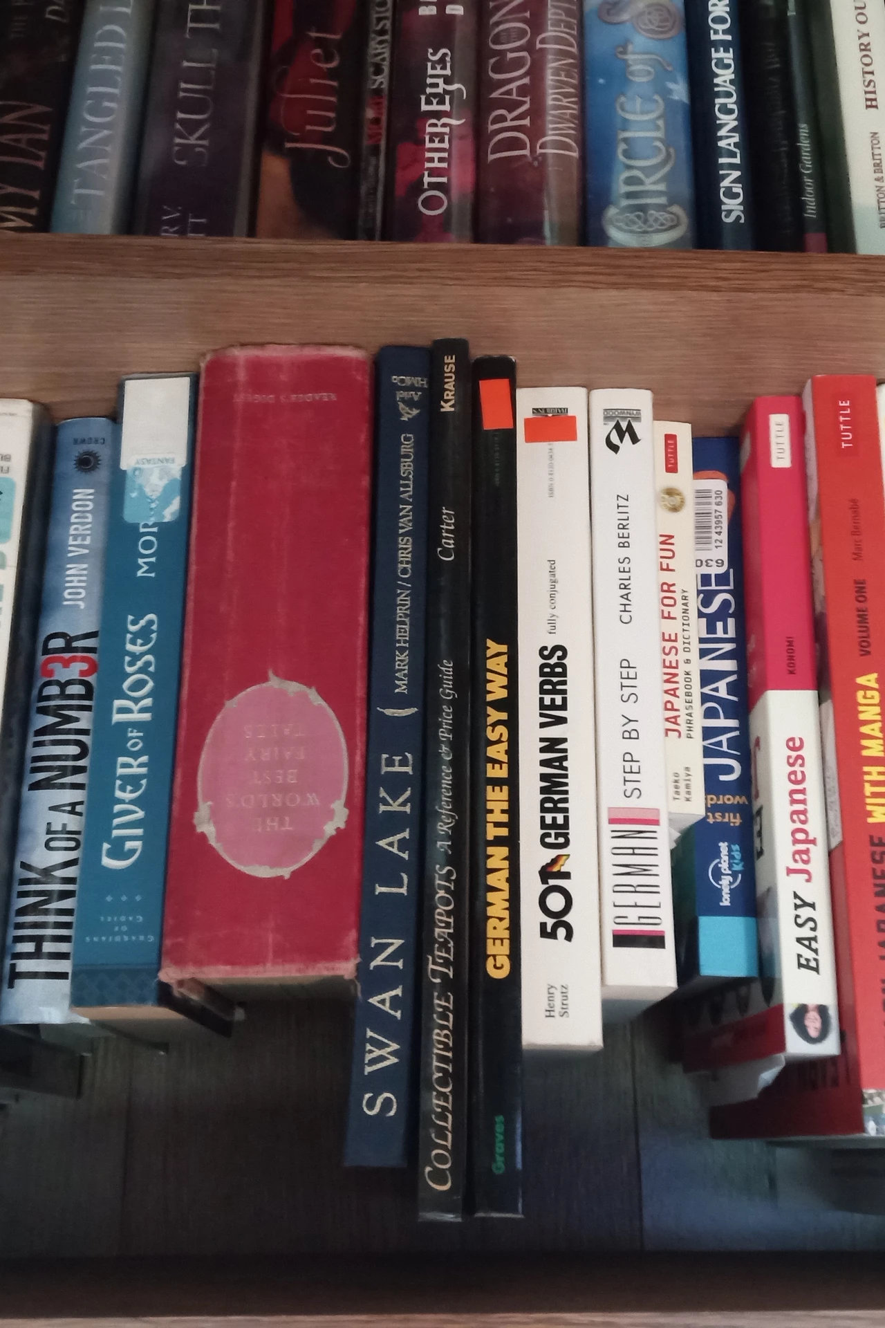 Shallow shelves behind a bedroom door holding books and small boxes