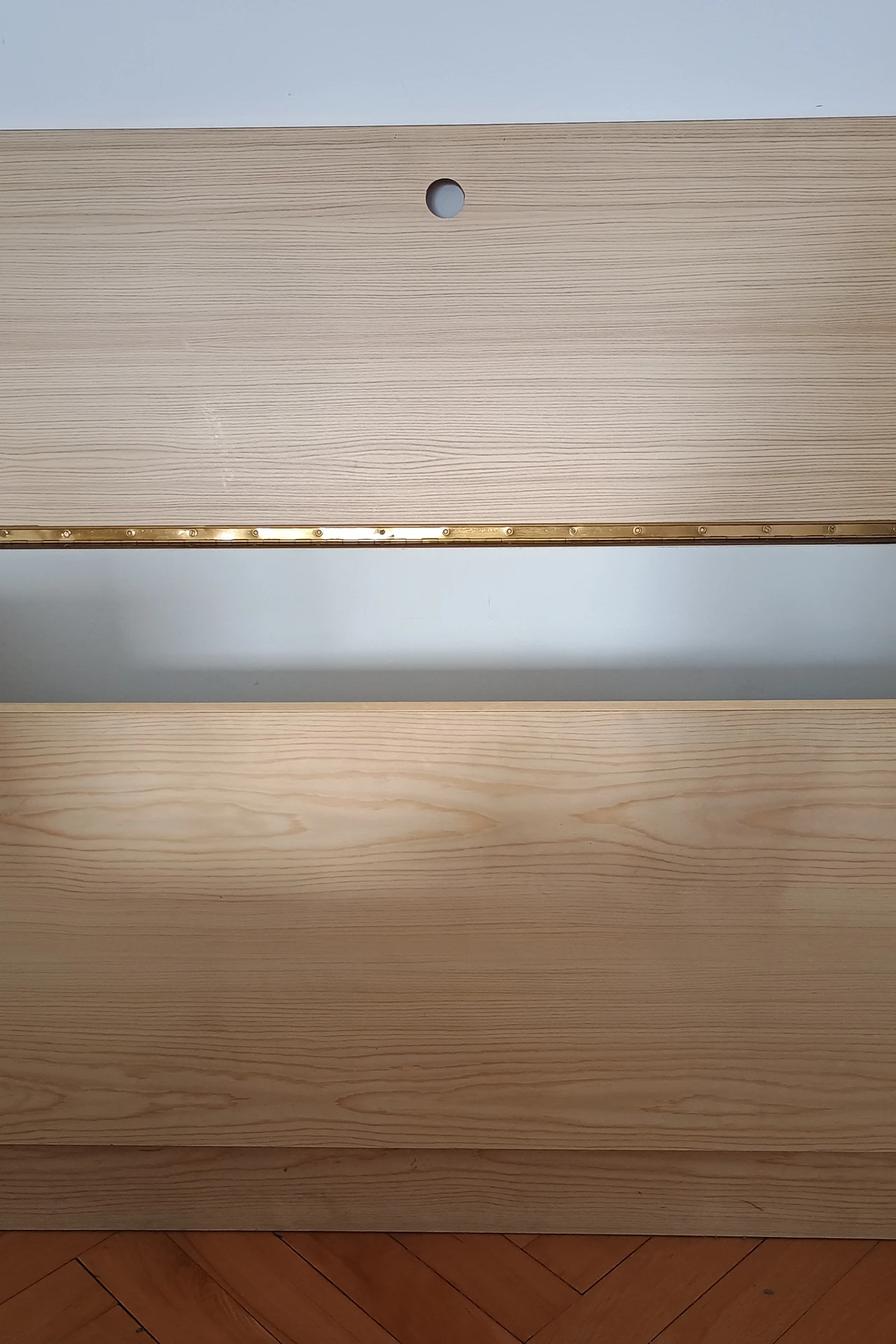Storage bench with cushion at the foot of a bed in a small bedroom