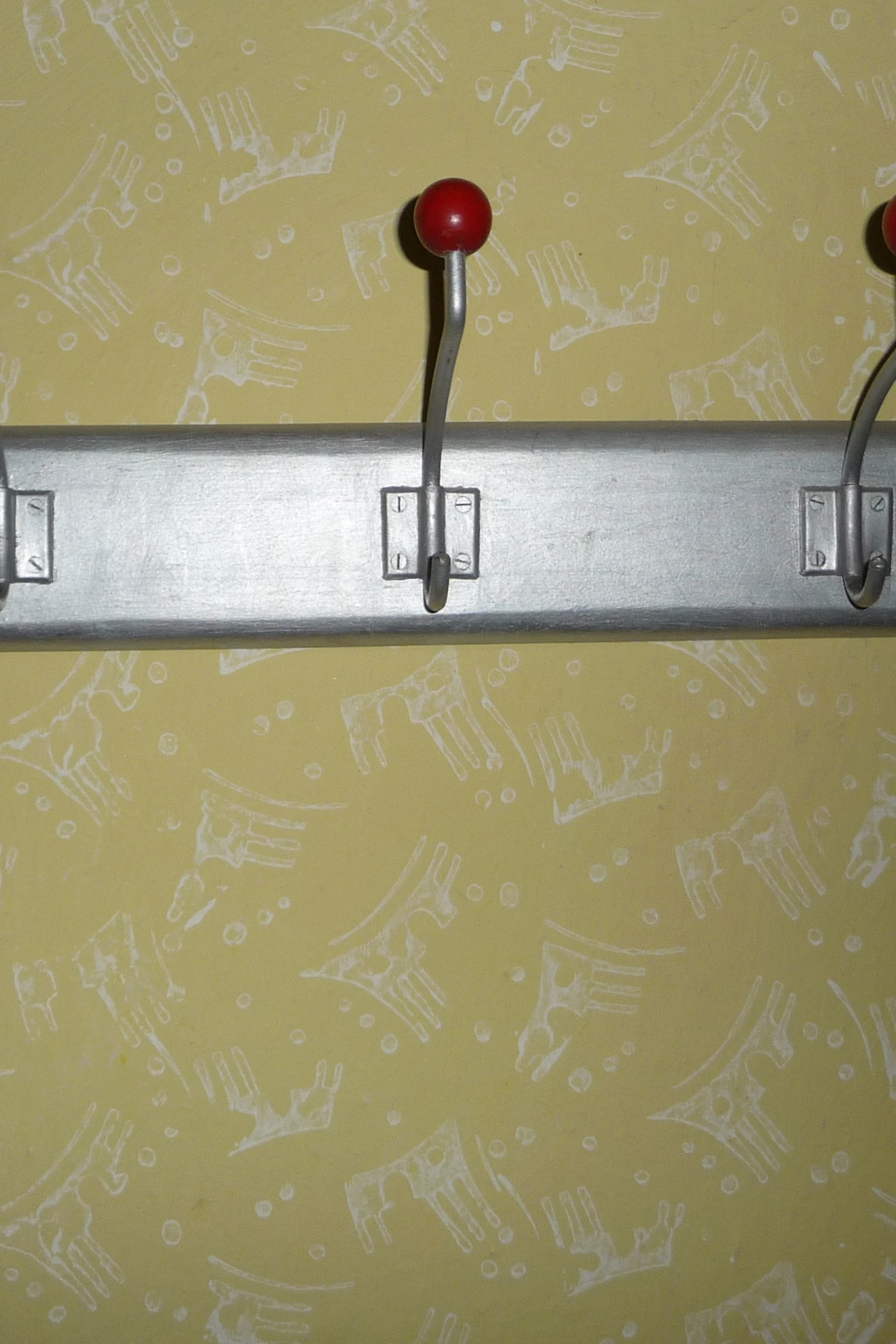 Wooden peg rail with coats and small baskets in a narrow hallway