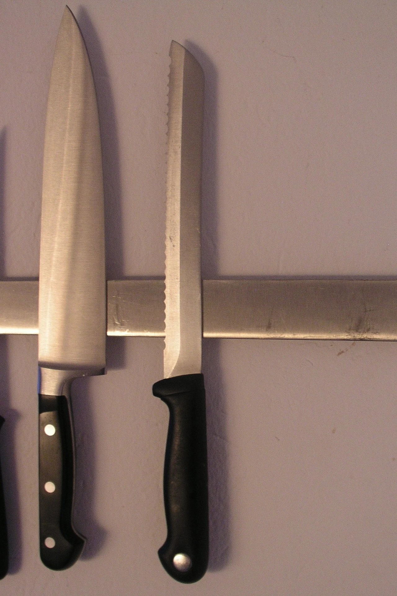 Magnetic knife strip holding kitchen knives on a small apartment kitchen wall
