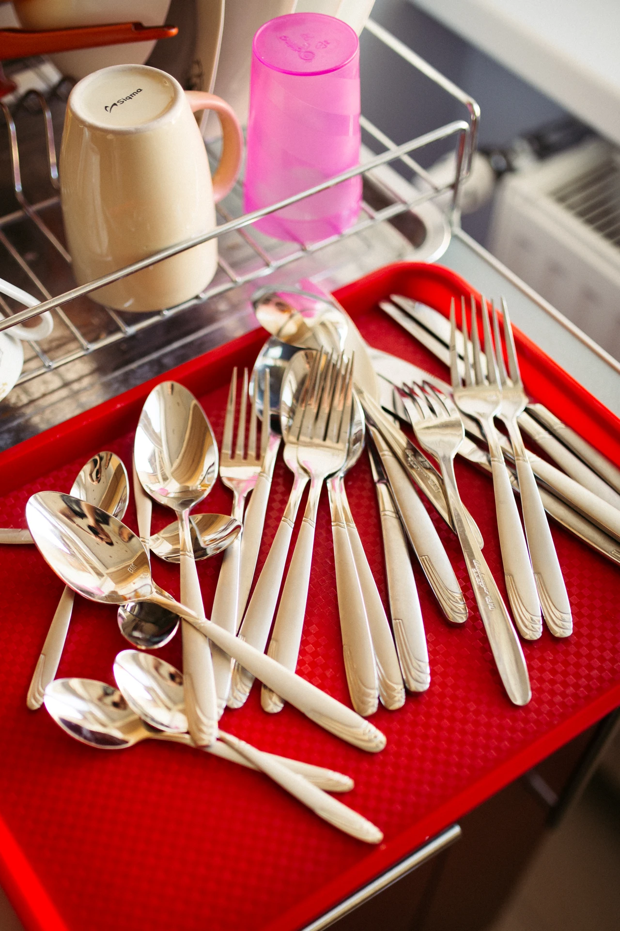 Over-the-sink dish rack holding clean plates and bowls above a small kitchen sink