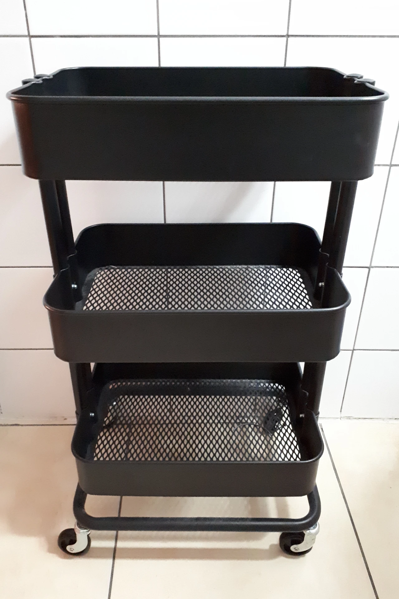 Rolling kitchen cart with butcher block top in a small apartment kitchen