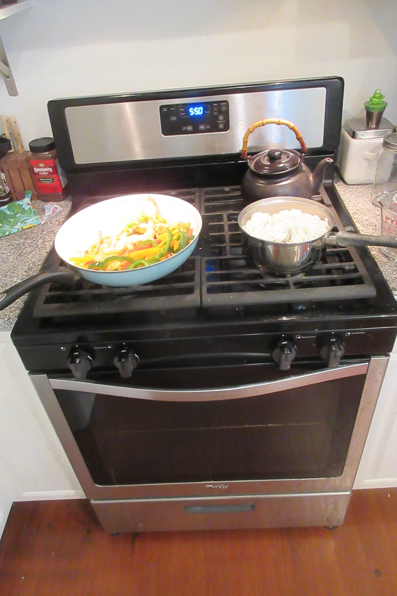 Wooden stove top cover board holding a fruit bowl in a small kitchen