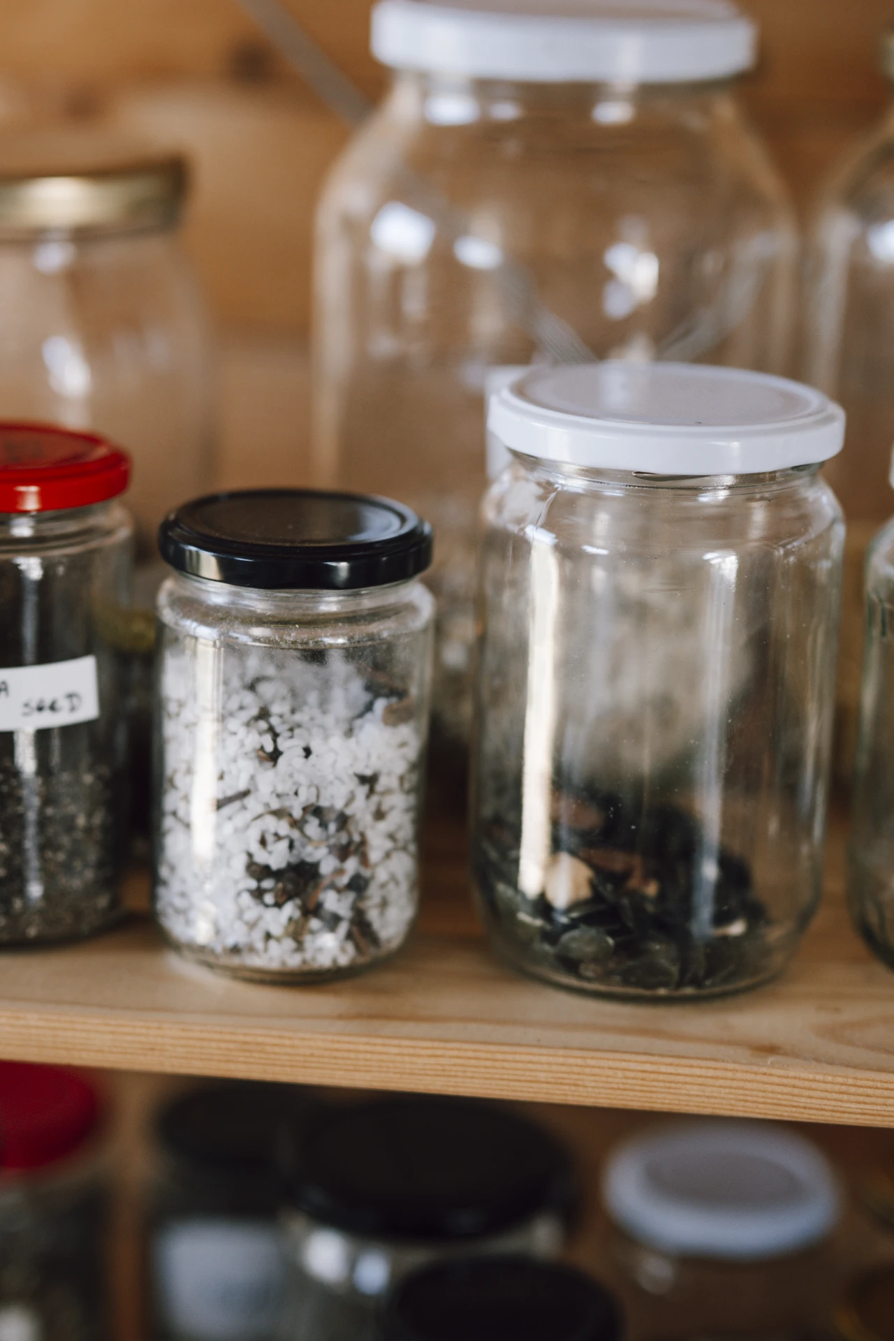 Clear stackable pantry bins organizing snacks and baking supplies in a kitchen cabinet