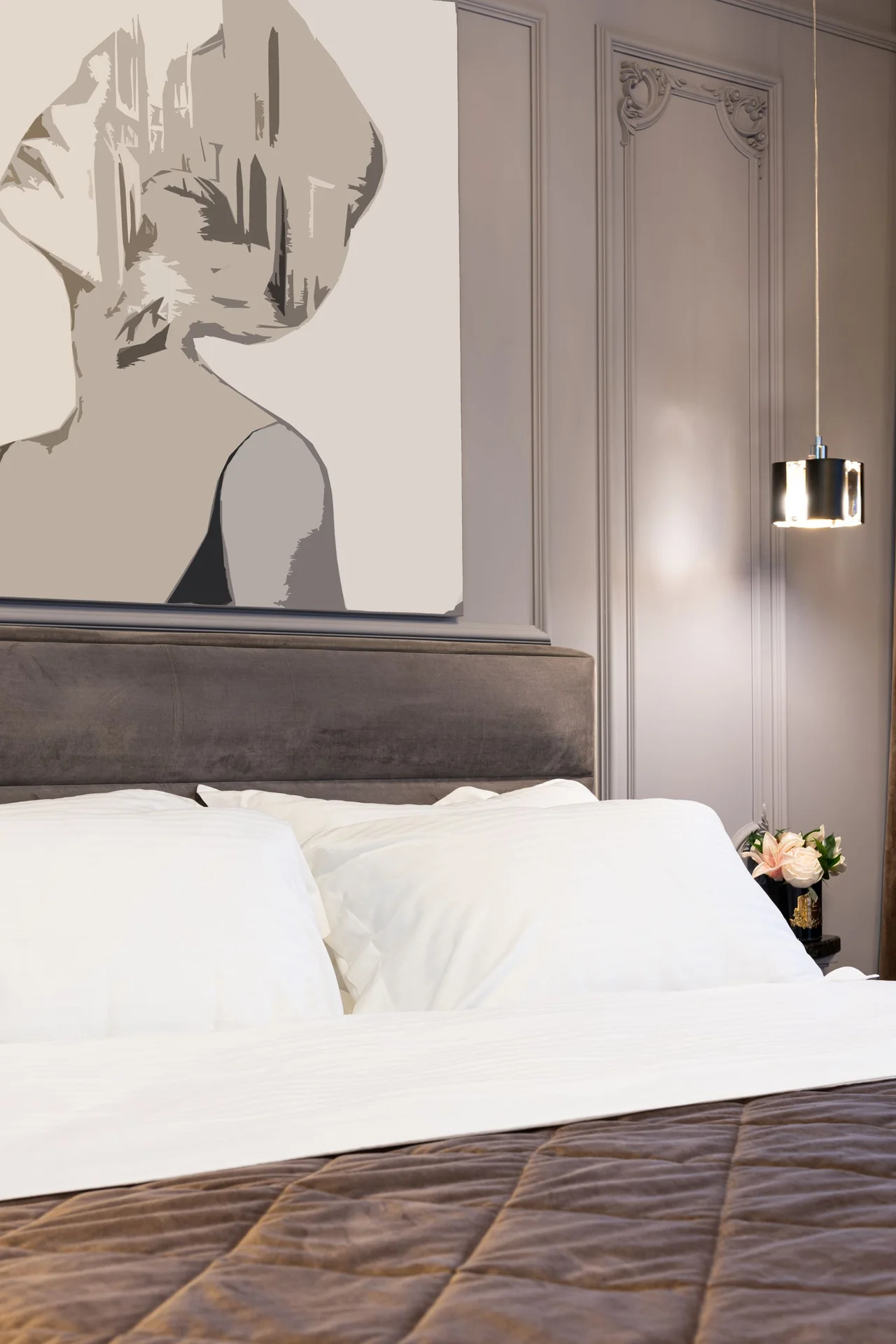 One large framed art print above a bed in a tiny bedroom