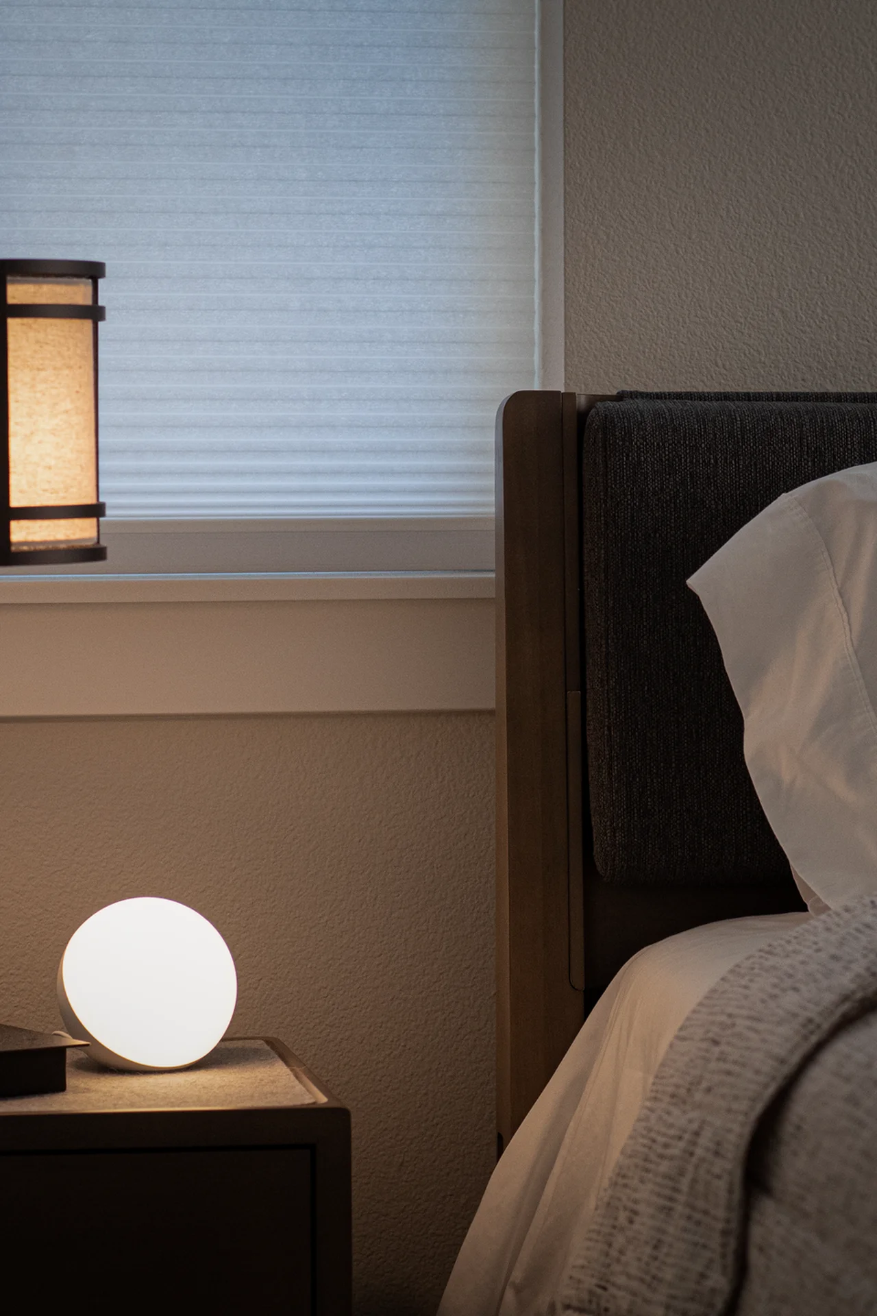 Narrow wall-mounted bedside shelf beside a bed in a tiny bedroom