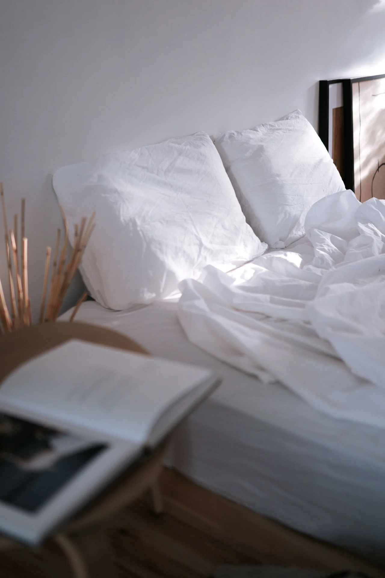 Bed dressed in soft neutral oatmeal and white bedding in a tiny bedroom