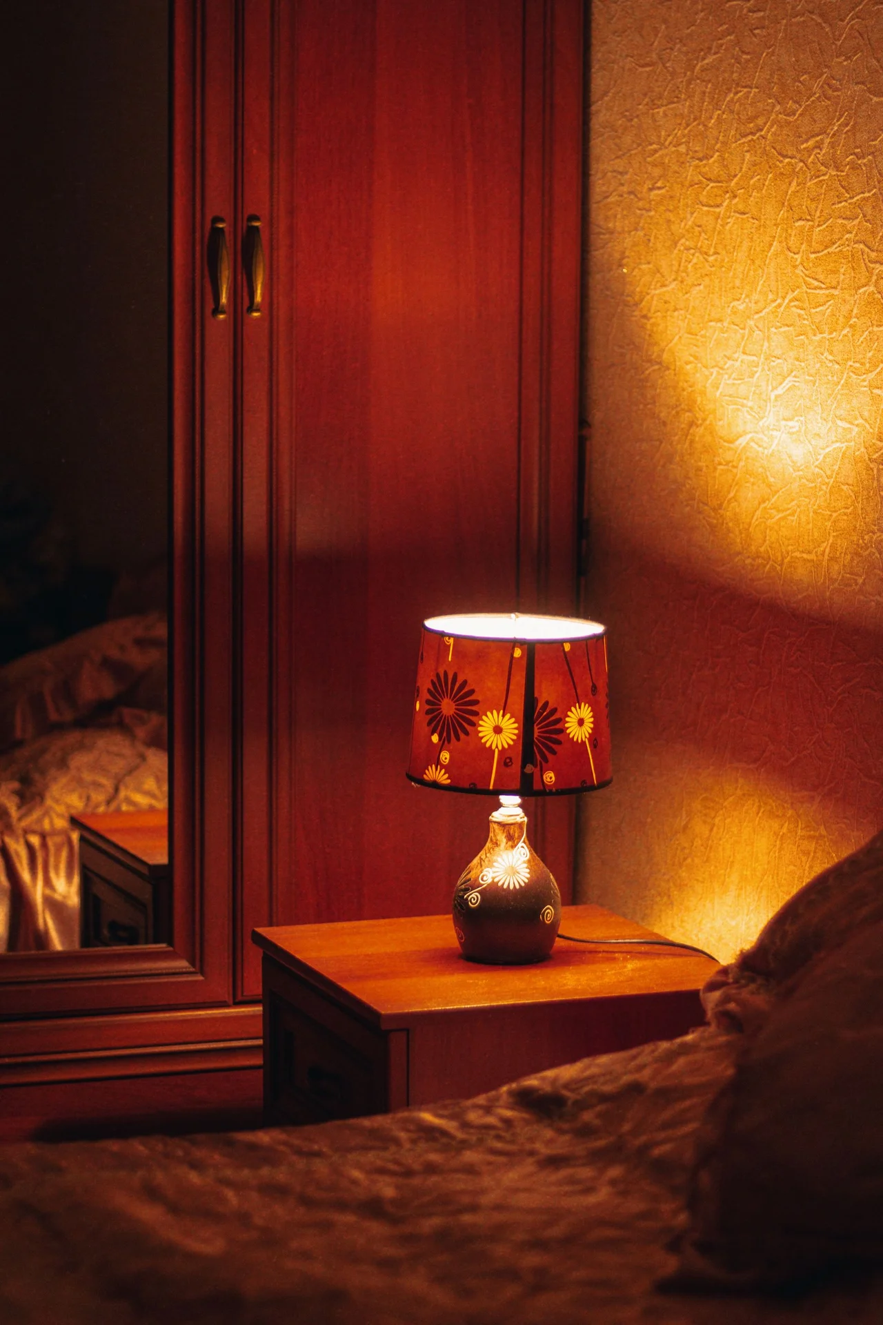 Wall-mounted swing-arm reading lights beside a bed in a small bedroom
