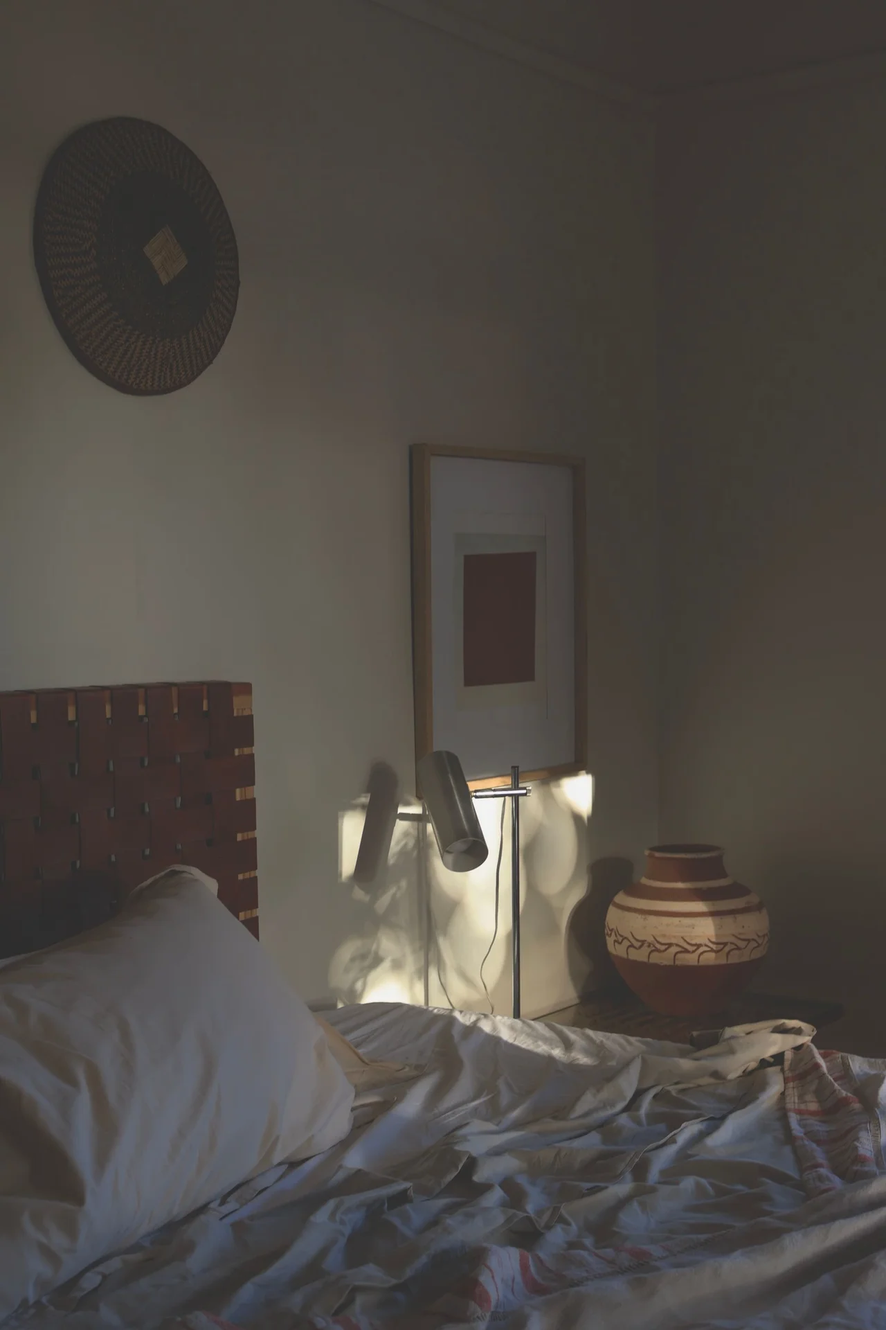 Tiny bedroom with one plain bare wall and minimal furniture