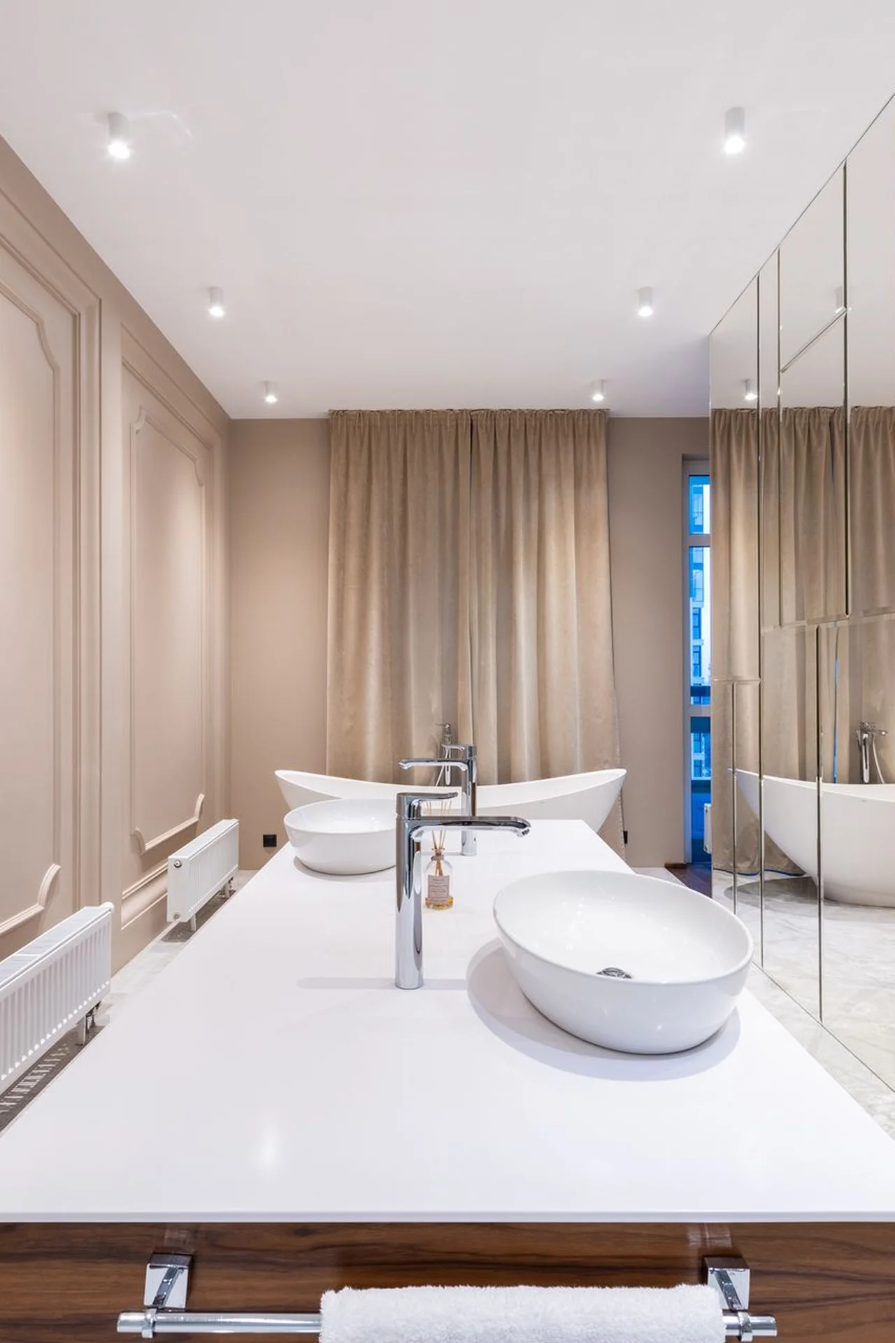 Large mirror above a small bathroom sink reflecting light
