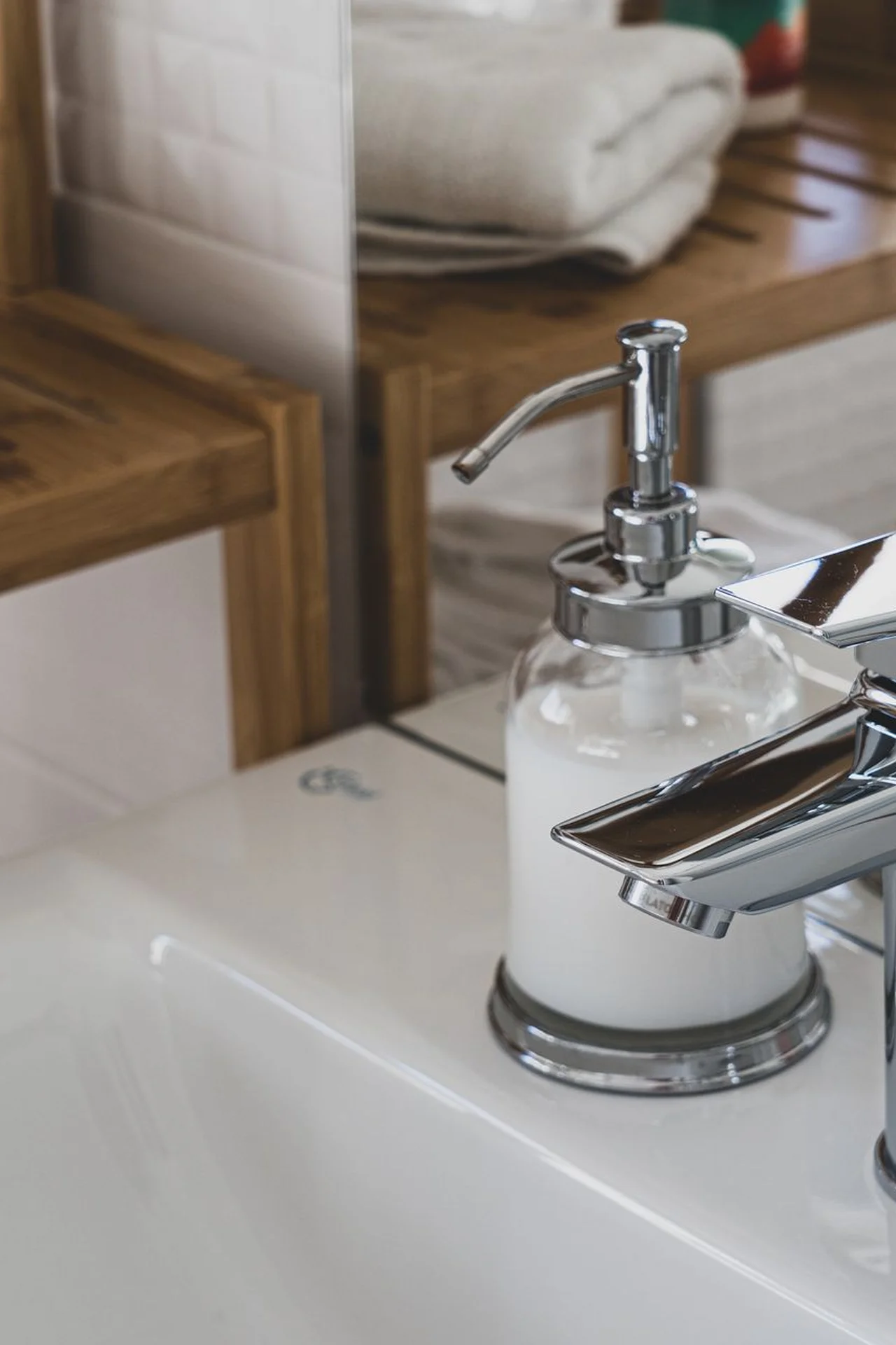 Small floating shelf beside a bathroom mirror holding toiletries