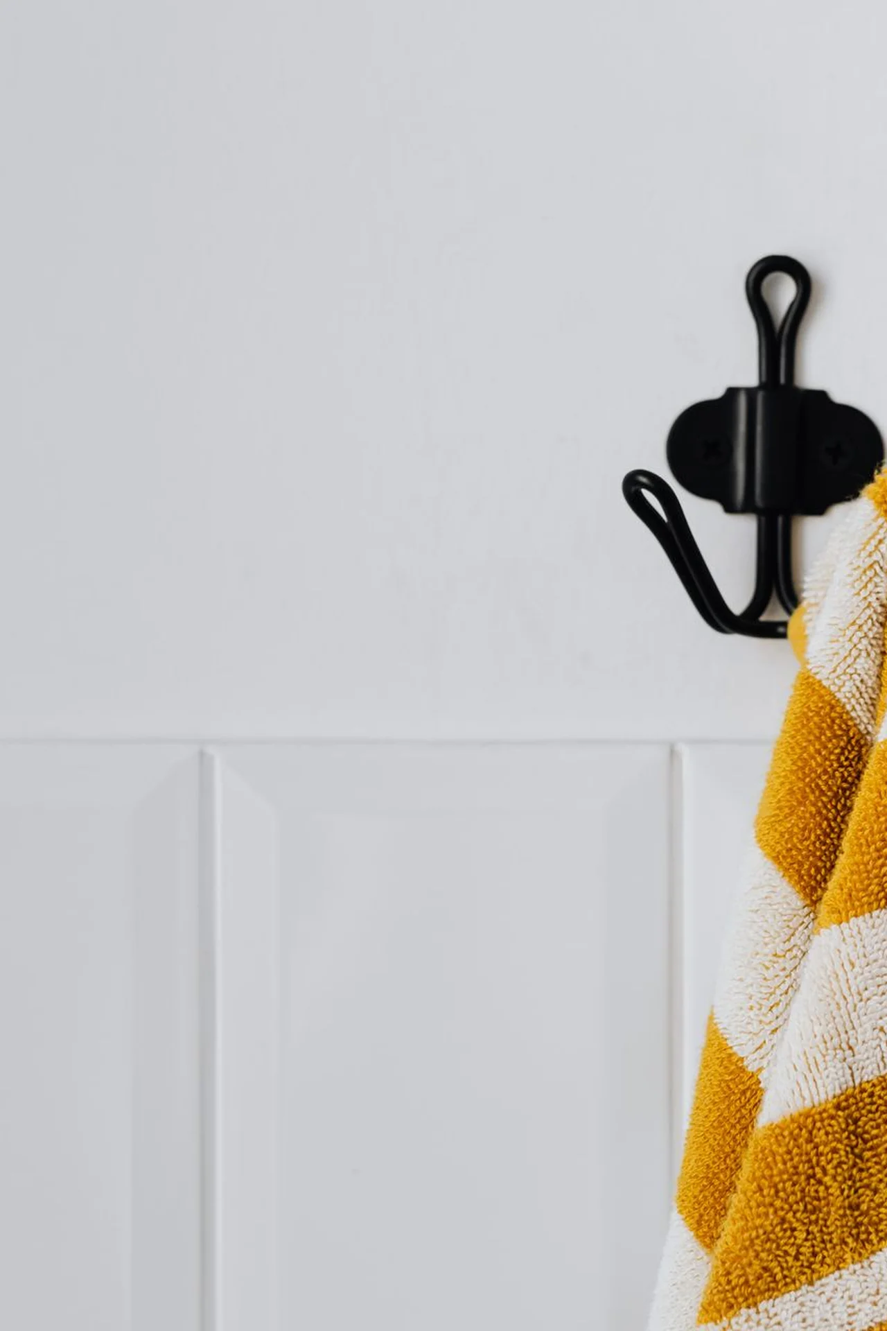 Over-door hook rack holding towels in a small bathroom