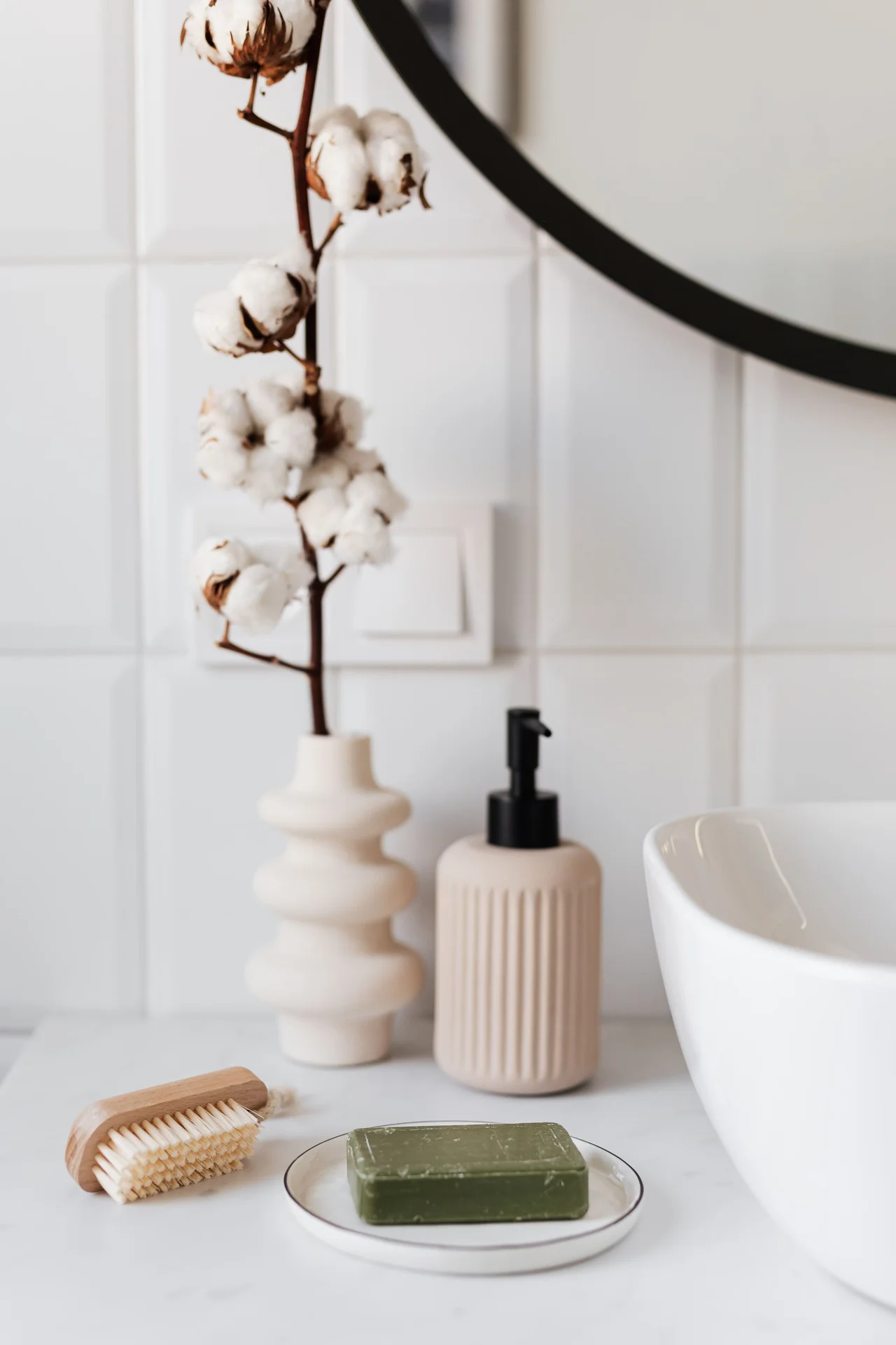 Glass jars holding cotton pads and bath salts in a bathroom